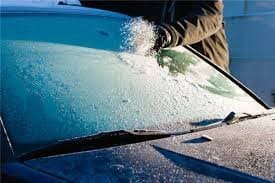 Person scraping ice off windshield